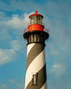 A towering black and white striped lighthouse with a red top against a blue sky, located at the St. Augustine Lighthouse & Maritime Museum, St. Augustine, Florida. St Augustine Lighthouse, Maritime Museum, Red Top