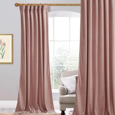 a living room with pink curtains and a chair