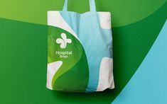 a green and blue shopping bag sitting on top of a colorful wall with the hospital logo