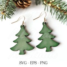 two wooden christmas trees are hanging from the tree branch, with pine cones in the background