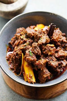 beef rendang in a bowl with spices on the side and text overlay that reads beef rendang