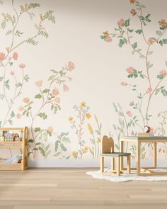 a child's room with flowers painted on the wall and wooden table in front