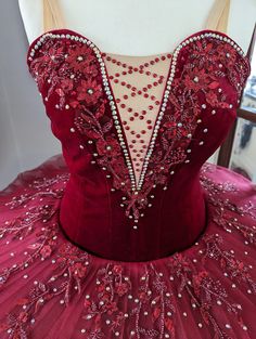 the back of a red dress with beading on it