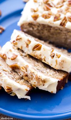 two slices of cake on a blue plate with pecans around it and one slice cut in half