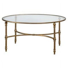 an oval glass table with gold metal legs