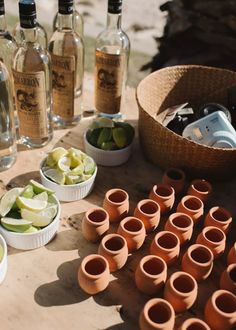 there are many bottles and bowls on the table