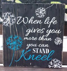 a wooden sign that says, when life gives you more than you can stand kneel