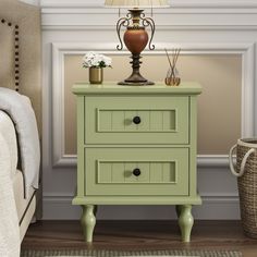 a nightstand with two drawers and a lamp on top