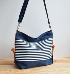 "The Marina no.2 bag has been designed for your everyday life, able to carry anything you may need during your daily activities The Marina bag is made from a waxed cotton canvas, combined with a nice navy and white striped pattern and has leather details at the sides. The bag closes with a metal zipper. the zipper can be open completely, providing you full access to the interior of the bag. The bag is fully lined with a cotton canvas. In the interior you will find a zipper pocket in one side and Canvas Diaper Bag With Adjustable Strap, Everyday Cotton Tote Diaper Bag, Everyday Canvas Diaper Bag With Adjustable Strap, Canvas Diaper Bag With Adjustable Strap For Daily Use, Everyday Canvas Shoulder Diaper Bag, Navy Canvas Bags For Everyday Use, Navy Canvas Tote Bag For Everyday Use, Everyday Canvas Diaper Bag, Navy Canvas Bag For Everyday Use