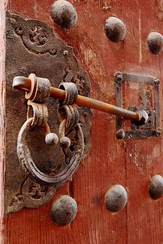 an old wooden door with some metal knobs on it