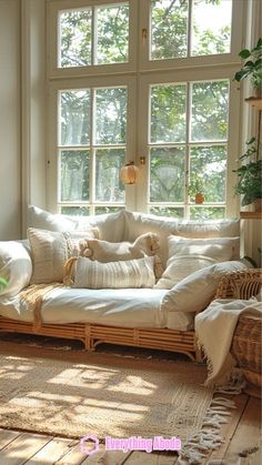 a living room filled with lots of furniture next to a large window and potted plant