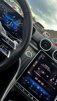 the inside of a car with an electronic device in it's center console and steering wheel