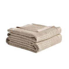 three folded towels stacked on top of each other in neutral colors, one beige and the other white