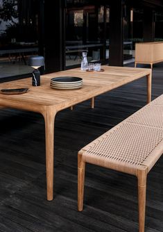 a wooden table with two chairs and a plate on it next to an empty bowl