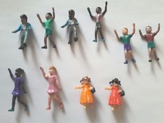 a group of toy people standing next to each other on top of a white surface