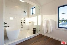 a bathroom with a tub, shower and window