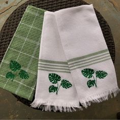 two green and white towels sitting on top of a table