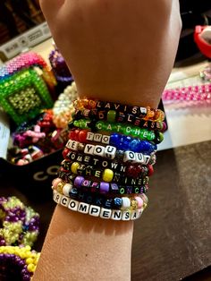 a person's arm with several different bracelets on top of it and beads all around the wrist