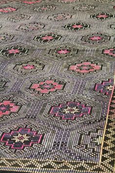 an old rug with pink and black designs on it