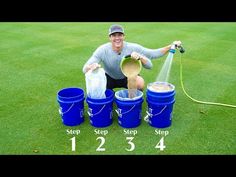 a man kneeling down next to buckets filled with sand and water on top of green grass