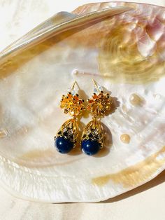 LAPIS LAZULI BLOOM EARRINGS Lustrous Gemstones: The Lapis Lazuli Bloom Earrings feature a design inspired by the delicate beauty of blooming flowers. At the heart of each earring, the deep blue Lapis Lazuli gemstones, known for their association with inner wisdom and truth, take center stage. Surrounding them is a meticulously crafted flower detail in 18K gold plated stainless steel, adding a touch of floral grace and sophistication to the design. Delicate Flower Detail: Lapis Lazuli Bloom Earri Inner Wisdom, Blue Lapis Lazuli, Delicate Beauty, Flower Detail, Blue Lapis, Stunning Earrings, Delicate Flower, Blooming Flowers, Center Stage