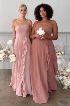 two women standing next to each other in dresses