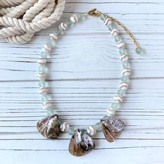 Real abalone seashells, mother of pearl, and imitation sea glass beads create this soft-toned, beach-themed statement necklace. Imagine this abalone vacation necklace styled with a white dress or blouse for an evening dinner after a day at the beach! Thank you for visiting Lenora Dame on Etsy! ~18.5-inches with 3-inch extension Abalone Shell-shaped Necklace For Beach, Abalone Shell Necklace For Beach, Ocean-inspired Abalone Shell For Beach, Ocean-inspired Abalone Shell Necklace, Beach Shell Necklace Made Of Mother Of Pearl, Mother Of Pearl Shell-shaped Necklace For The Beach, Ocean-inspired Shell Beaded Necklaces, White Abalone Shell Necklace For Beach, White Abalone Shell Beach-style Necklace