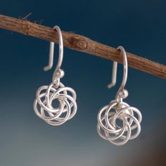 This pretty pair of dangle earrings is designed by Peru's Marina Guzman. The interlocking spiral earrings are crafted from Andean sterling silver with a brightly polished finish. Handmade Sterling Silver Earrings With A Modern Twist, Sterling Silver Swirl Earrings For Gift, Swirl Shaped Sterling Silver Earrings For Gifts, Modern Twist Sterling Silver Pierced Jewelry, Modern Twist Dangle Earrings As Gift, Modern Twist Dangle Earrings For Gift, Hypoallergenic Sterling Silver Swirl Earrings, Modern Twist Silver Spiral Earrings, Spiral Sterling Silver Earrings For Gift