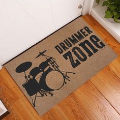 a door mat that says drummer 2009 on it in front of a drum set and potted plant