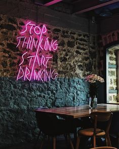 a table and chairs in front of a brick wall with graffiti on the wall behind it