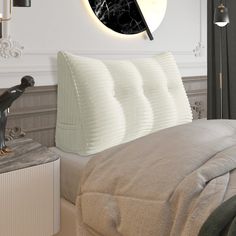 a bed with a black and white clock on the wall