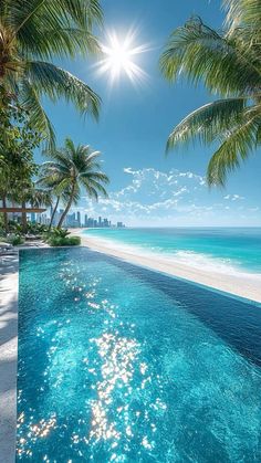 an empty swimming pool with palm trees and the ocean in the background