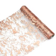 a rolled up piece of copper foil on top of a white surface with lots of glitter