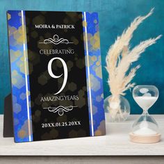 a blue and black photo frame with the number nine on it, next to an hourglass