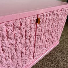 a pink dresser with gold knobs on it