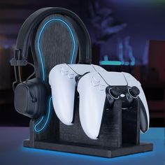 two video game controllers sitting on top of a wooden stand with headphones attached to it