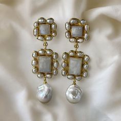 Elevate your bridal ensemble with these stunning handmade moonstone and baroque pearl statement earrings, perfect for weddings and special occasions. These exquisite earrings are designed to make you shine on your special day. Each earring features a genuine square-cut moonstone (approximately 13mm x 13mm) surrounded by delicate, genuine tiny rice pearls. The moonstone's iridescent glow is captivating, making it a standout piece. The connector of the earrings is equally breathtaking, with a rectangular-cut moonstone (approximately 21mm x 23mm) adorned with more tiny rice pearls. Suspended from the connector is a matched medium-sized, lustrous cultured baroque pearl (approximately 14mm to 15mm x 17mm to 18mm), adding a touch of elegance and sophistication. These earrings are more than beaut Luxury Mother Of Pearl Earrings For Wedding, Pearl White Mother Of Pearl Wedding Earrings, Luxury Mother Of Pearl Wedding Earrings, Wedding Pearl White Mother Of Pearl Earrings, Wedding Pearl Drop Earrings In Mother Of Pearl, Wedding Mother Of Pearl Drop Earrings, Mother Of Pearl Bridal Earrings For Wedding, Luxury Handmade Chandelier Earrings For Weddings, Luxury Pearl Embellished Earrings For Wedding