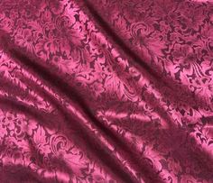 a pink fabric with an intricate design on it's side and the background is very soft