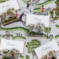 several place cards with horse and carriage on them sitting on top of a tablecloth