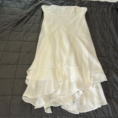 a white dress laying on top of a bed