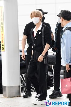 two people wearing masks are walking through an airport