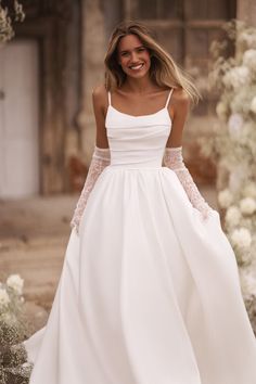 a woman in a white wedding dress is smiling