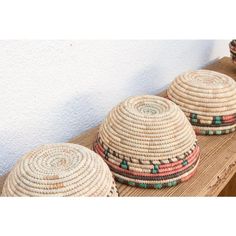 three baskets sitting on top of a wooden table next to each other with different designs