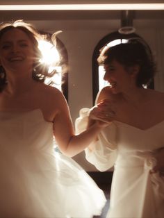 two women in white dresses looking at each other