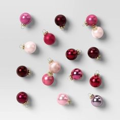 christmas ornaments are arranged in different colors and sizes on a white surface, top view