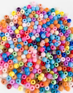 multicolored beads are scattered on a white surface