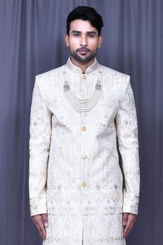 Light beige banglori silk sherwani with floral and thread embroidery. Comes with off-white banglori silk churidar and art silk anarkali kurta.
Components: 3
Pattern: Embroidered
Type Of Work: Floral, Thread
Neckline: Mandarin collar
Sleeve Type: Full
Fabric: Sherwani: Banglori silk, Churidar: Satin silk, Anarkali Kurta: Art silk
Color: Beige
Other Details: 
Closure: Sherwani - Front buttons
Note: Mala worn by the model is not for sale.
Occasion: Wedding,Groom - Aza Fashions Ceremonial Cream Nehru Jacket With Zari Work, Ceremonial Cream Bandhgala With Chikankari Embroidery, Ceremonial Beige Zari Work Sherwani, Ceremonial Beige Sherwani With Zari Work, Ceremonial Beige Bandhgala With Intricate Embroidery, Off White Bandhgala With Zari Work Traditional Drape, Beige Naqshi Bandhgala With Traditional Drape, Beige Bandhgala With Naqshi In Traditional Drape, Off White Naqshi Bandhgala For Festive Occasions