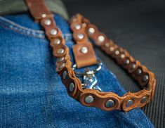 a blue jean jacket with leather straps and studded metal clasps on the back