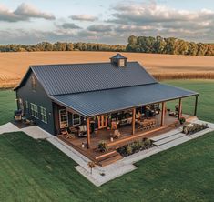 an aerial view of a house in the middle of a field with a blue tin roof