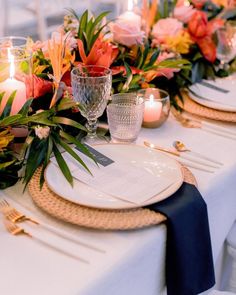 a table set with flowers and candles for an elegant dinner or party setting in shades of pink, orange and yellow